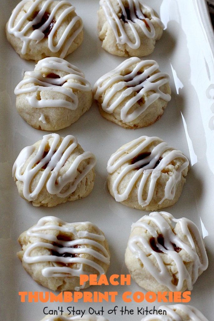 Peach Thumbprint Cookies | these fantastic little #cookies are terrific for #holiday #baking & #ChristmasCookieExchanges. They're filled with #peach jam & iced with a heavenly vanilla powdered sugar icing. #dessert #holiday #HolidayDessert ChristmasDessert #ChristmasCookie #PeachDessert #ThumbprintCookie