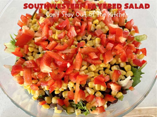 Southwestern Layered Salad | Can't Stay Out of the Kitchen | this scrumptious #LayeredSalad is perfect for company or a crowd since it makes a lot! If you enjoy #TexMex flavor in your #salad or a #TacoSalad this #salad will be right up your alley. The #Southwestern flavors are marvelous & the heartiness of two types of #beans & #corn make this a #MainDishSalad that can't be beat! #bacon #tomatoes #CheddarCheese #Fritos #olives #RanchDressing #FritosCornChips #avocados #pork #SouthwesternLayeredSalad #GlutenFree