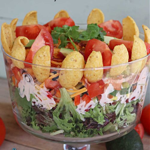 Southwestern Layered Salad | Can't Stay Out of the Kitchen | this scrumptious #LayeredSalad is perfect for company or a crowd since it makes a lot! If you enjoy #TexMex flavor in your #salad or a #TacoSalad this #salad will be right up your alley. The #Southwestern flavors are marvelous & the heartiness of two types of #beans & #corn make this a #MainDishSalad that can't be beat! #bacon #tomatoes #CheddarCheese #Fritos #olives #RanchDressing #FritosCornChips #avocados #pork #SouthwesternLayeredSalad #GlutenFree