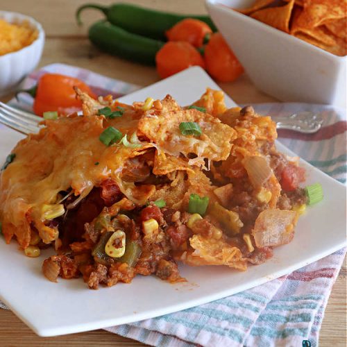 Spicy Nacho Bake | Can't Stay Out of the Kitchen | let this scrumptious #TexMex #entree captivate you with its delicious filling layered between layers of #NachoCheeseDoritos & #CheddarCheese. The filling includes #GroundBeef #corn #tomatoes, #TacoSeasoning, #ChiliBeans & #BlackBeans. This tasty #casserole can be whipped up & ready to serve in about an hour. #SpicyNachoBake